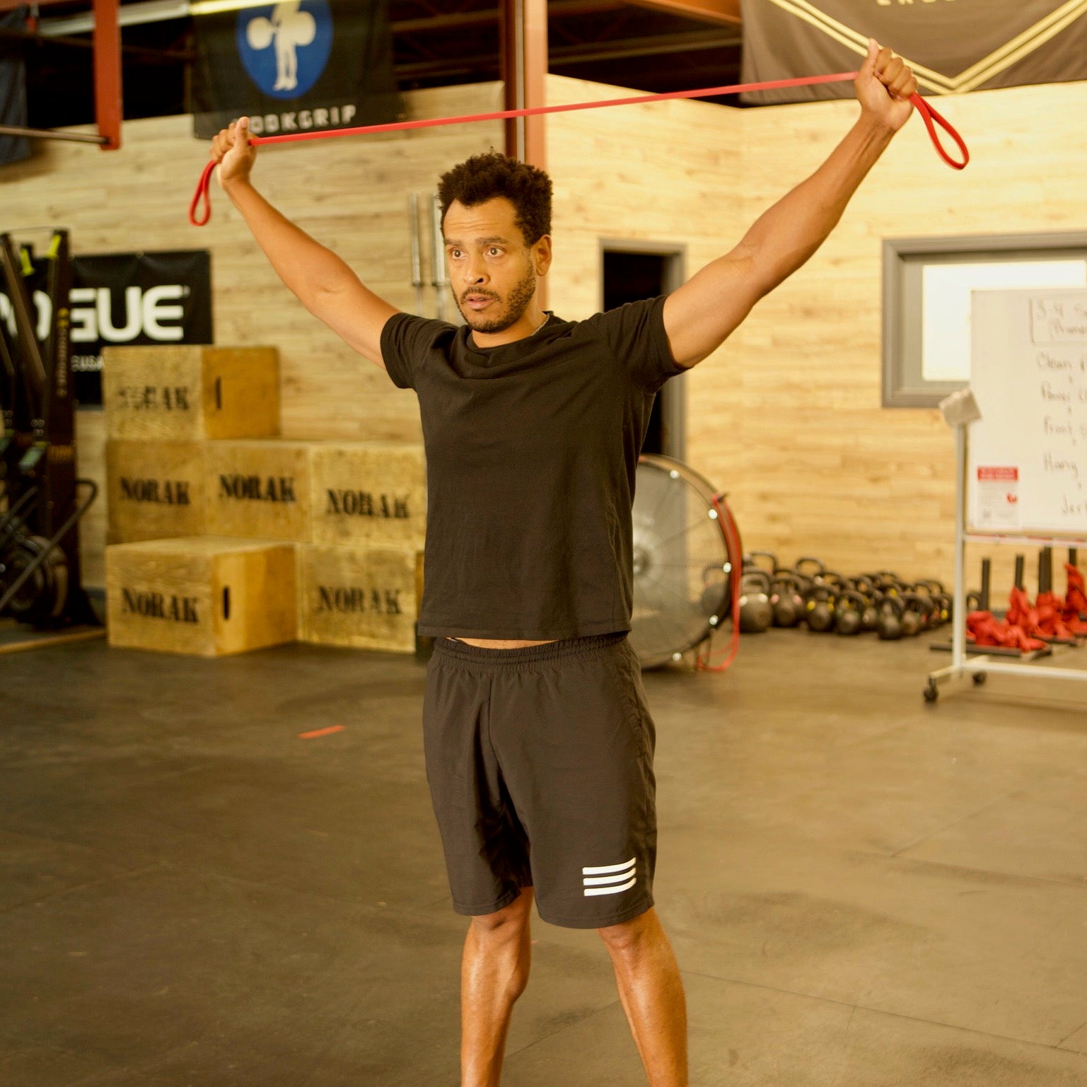 Man using medium-light exercise band to mobilize shoulders