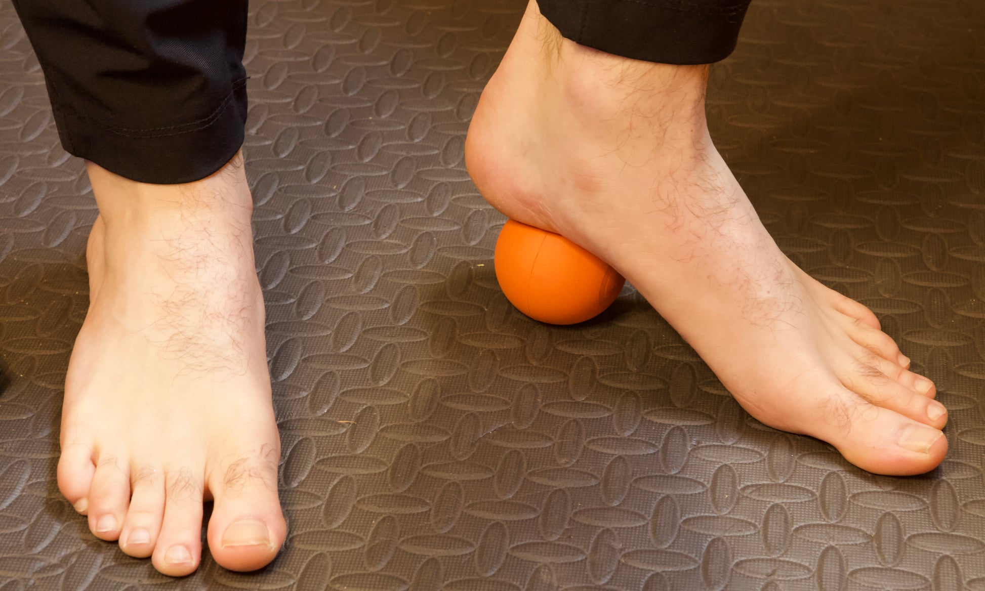 Man using massage ball to treat plantar fasciitis