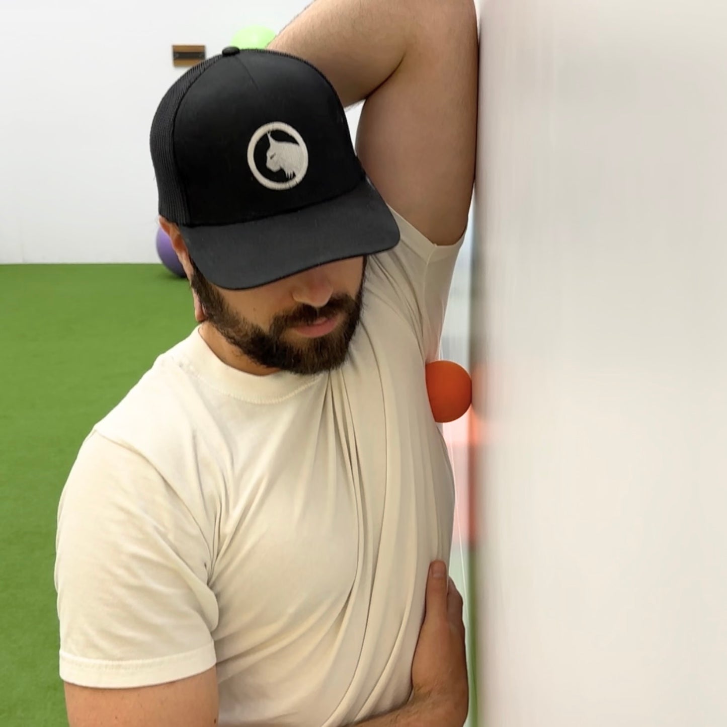 Man using lacrosse ball to release tension in muscles around the shoulder