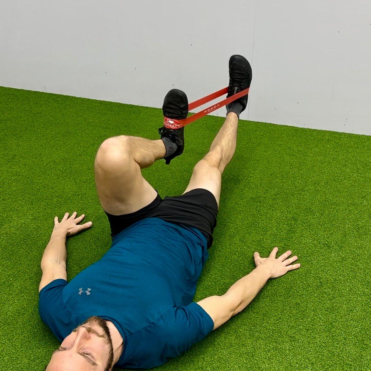 Man using mini exercise band to strengthen hip flexors