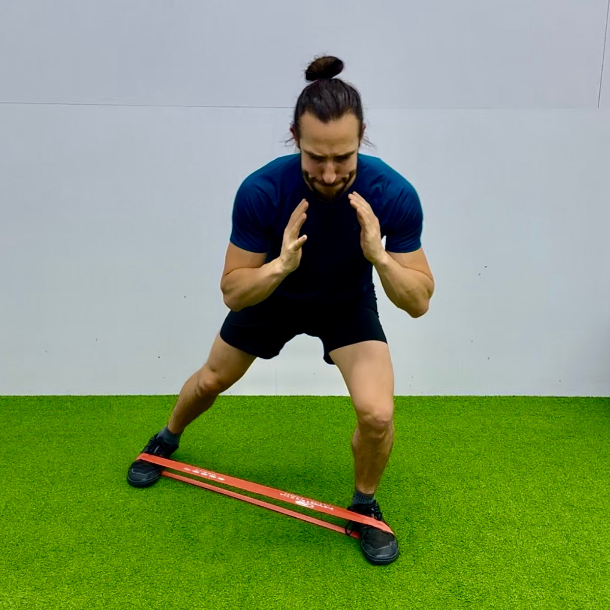 Man using mini exercise band to strengthen glute med muscles